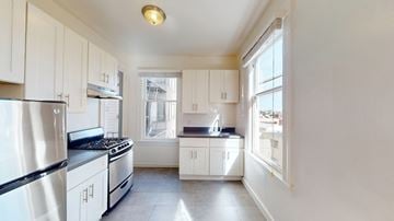 San Francisco apartment for rent - A kitchen with white cabinets and a stainless steel refrigerator.