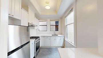 San Francisco apartment for rent - A kitchen with white cabinets and a stainless steel refrigerator.
