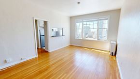 San Francisco apartment for rent - A room with wooden floors and a window overlooking a cityscape.
