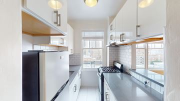 San Francisco apartment for rent - A modern kitchen with a black refrigerator and white cabinets.