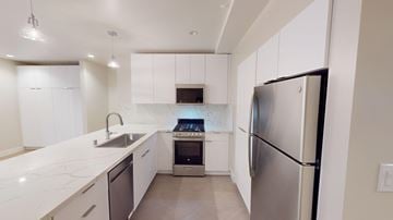 San Francisco apartment for rent - A modern kitchen with white cabinets and a stainless steel refrigerator.