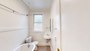 San Francisco apartment for rent - A white bathroom with a tub, sink, and toilet.