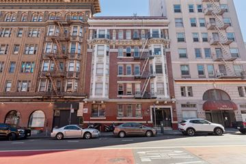 San Francisco apartment for rent - A street view of a city with buildings, cars and a fire escape.