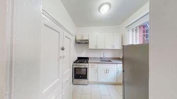 San Francisco apartment for rent - A kitchen with white cabinets and a stainless steel refrigerator.