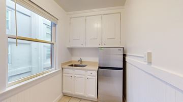 San Francisco apartment for rent - A kitchen with white cabinets and a stainless steel refrigerator.