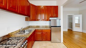 San Francisco apartment for rent - A kitchen with wooden cabinets and a stainless steel refrigerator.