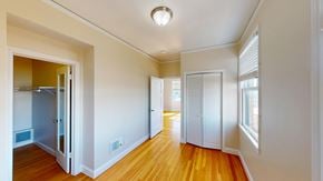 San Francisco apartment for rent - A long hallway with a refrigerator on the left and a door on the right.