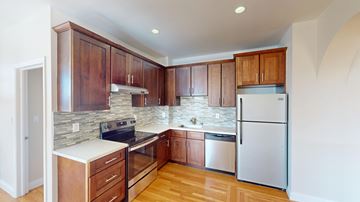 San Francisco apartment for rent - A kitchen with wooden cabinets and a white countertop.