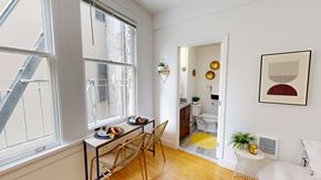 San Francisco apartment for rent - A dining table with chairs is set up in a room with a window.