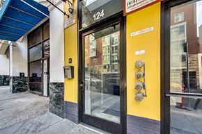 San Francisco apartment for rent - The image shows the front of a building with a yellow wall and a glass door.
