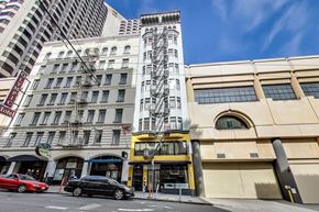 San Francisco apartment for rent - A tall building with a yellow and black structure in front of it.