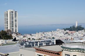San Francisco apartment for rent - A cityscape with a tall building on the left and a lighthouse in the distance.