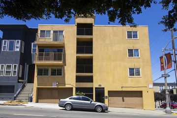 San Francisco apartment for rent - A tan building with a car parked in front.
