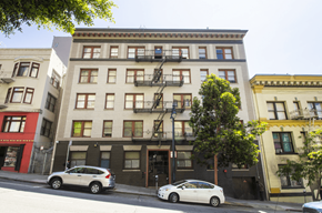 San Francisco apartment for rent - A white car is parked on the street in front of a building with a fire escape.