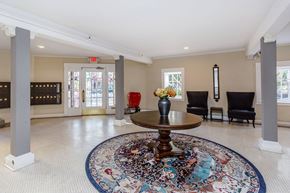 San Francisco apartment for rent - A large, round rug with a multicolored design is placed in the middle of a spacious room with a wooden table and chairs.