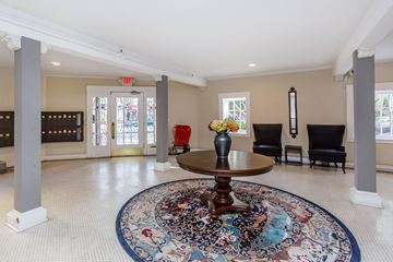 San Francisco apartment for rent - A large, round rug with a multicolored design is placed in the middle of a spacious room with a wooden table and chairs.