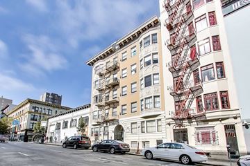 San Francisco apartment for rent - A white building with a red fire escape on the side.