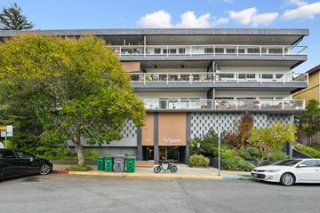 Berkeley apartment for rent - A parking lot with a building and a tree in front of it.