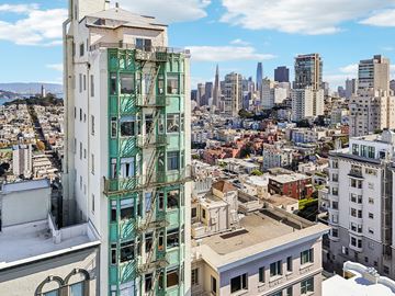 San Francisco apartment for rent - A cityscape with a green building in the foreground.