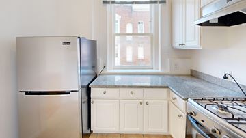 San Francisco apartment for rent - A kitchen with a stainless steel refrigerator and a stove top oven.
