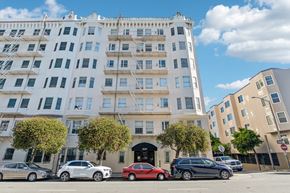 San Francisco apartment for rent - A red car is parked in front of a white building.