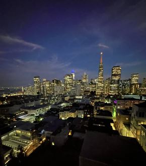 San Francisco apartment for rent - Photo from 267-273 Green Street shows a breathtaking nighttime view of San Francisco's skyline, featuring the glowing Transamerica Pyramid and the distant Bay Bridge under a deep blue sky.