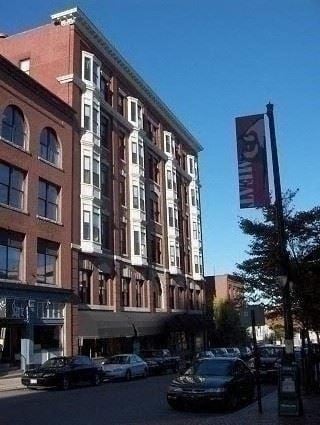 Portland apartment for rent - A tall building with a red brick facade stands on a street corner.