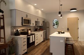 Biddeford apartment for rent - A modern kitchen with white cabinets and a wooden island.