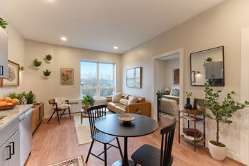 Biddeford apartment for rent - A well-lit, modern kitchen and living room with a dining table and chairs.