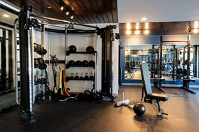 Biddeford apartment for rent - A gym with a squat rack, bench, and weights.