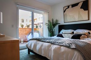 Portland apartment for rent - a bedroom with a bed and a sliding glass door to a balcony