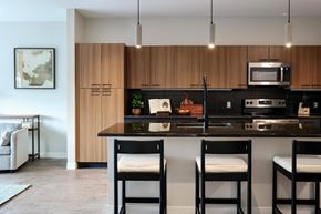 Portland apartment for rent - a kitchen with wooden cabinets and a counter with three stools