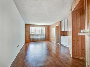 Van Nuys apartment for rent - an empty living room with wooden floors and a kitchen
