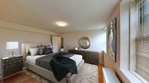 Troy apartment for rent - A bedroom with a large bed and a mirror on the wall.