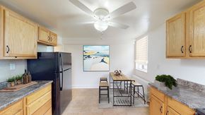 Troy apartment for rent - A kitchen with wooden cabinets and a black refrigerator.