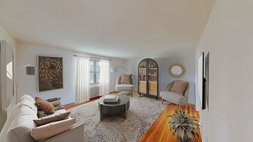Troy apartment for rent - A living room with a white couch, a coffee table, and a painting on the wall.
