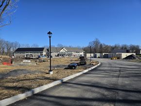 Fairport apartment for rent - a view of a building from the road with a street light