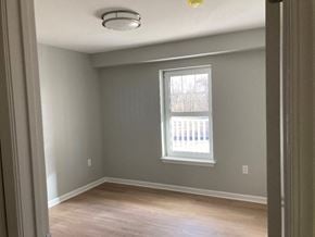 Fairport apartment for rent - an empty room with a window and wooden floors