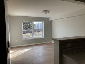 Fairport apartment for rent - a living room with a large window and wooden floors
