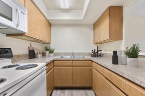 Kent apartment for rent - A kitchen with wooden cabinets and a white stove top oven.
