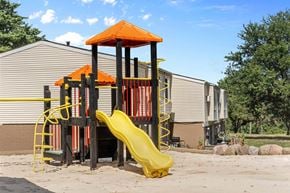 Kent apartment for rent - A playground with a yellow slide and an orange roofed structure.