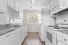Cuyahoga Falls townhouse for rent - A kitchen with white cabinets and a marble countertop.