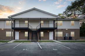 Statesboro apartment for rent - A two-story apartment building with a parking lot in front.