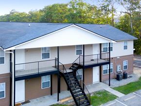 Statesboro apartment for rent - A two-story apartment building with a black metal staircase.