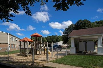 Kent apartment for rent - a playground with a swing set in front of a house