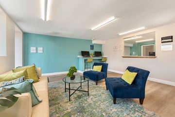 Philadelphia apartment for rent - A living room with a blue chair and a glass table.