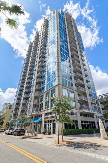 Tampa apartment for rent - A tall building with many windows is located on a street corner.