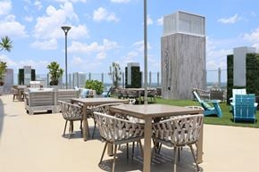 Tampa apartment for rent - A modern outdoor dining area with wooden tables and chairs.