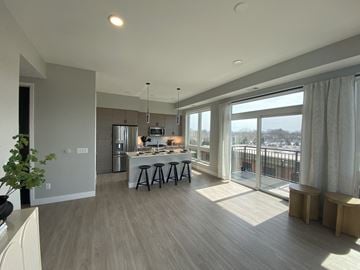 Minneapolis apartment for rent - a kitchen and living room with a large window and a table with stools
