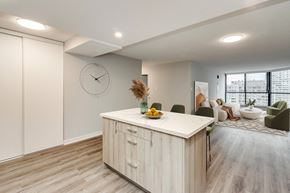 Brampton apartment for rent - an open kitchen and living room with a large clock on the wall